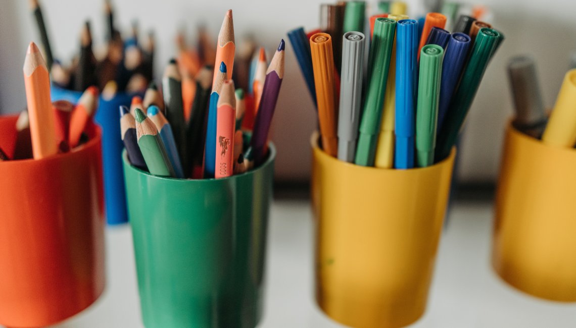 Bunte Becher mit vielen bunten Stiften