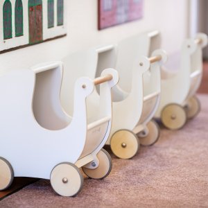 Kinderw&auml;gen zum Spielen f&uuml;r die Kinder stehen an einer Wand aufgereiht.
