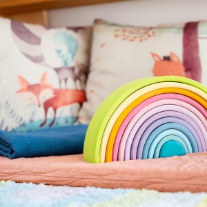 Kissen, eine kleine Matratze und Baukl&ouml;tze in Regenbogen-Farben.