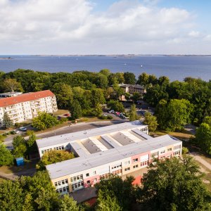 Eine Drohnenaufnahme der Tagesgruppe. Im Hintergrund ist das Meer zu sehen.